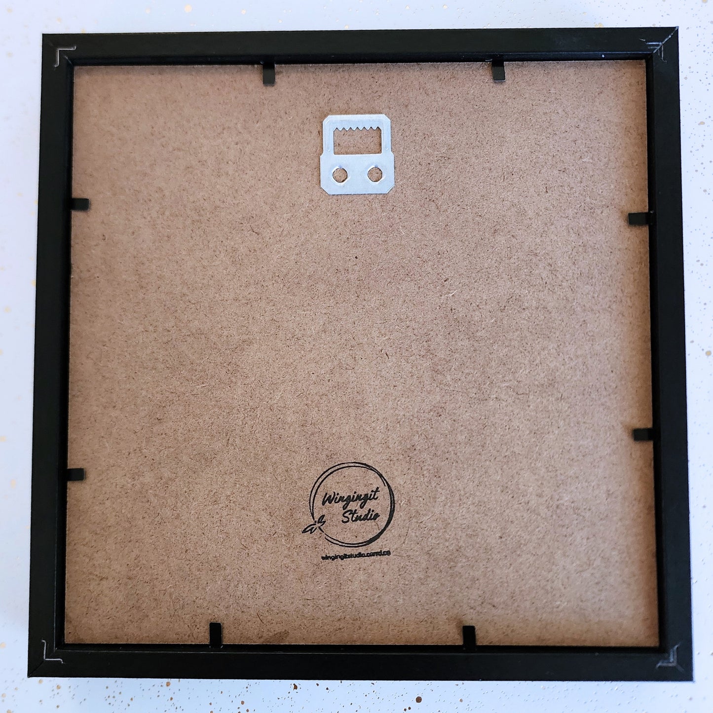 Back of a framed shadow box with visible brand logo "Wingingit Studio".