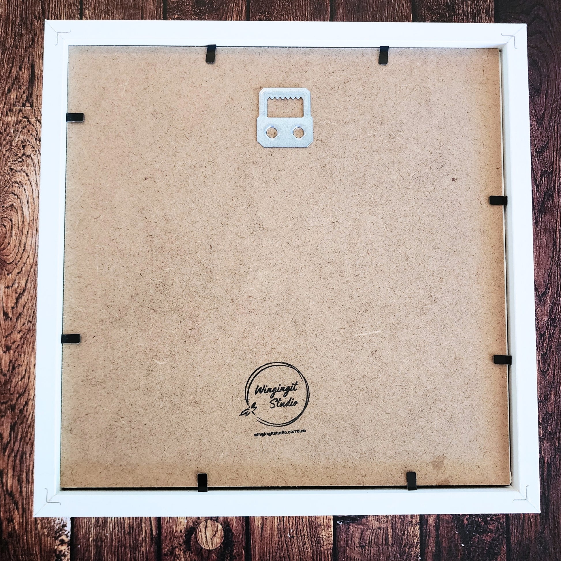 Back of a framed shadow box with visible brand logo "Wingingit Studio".